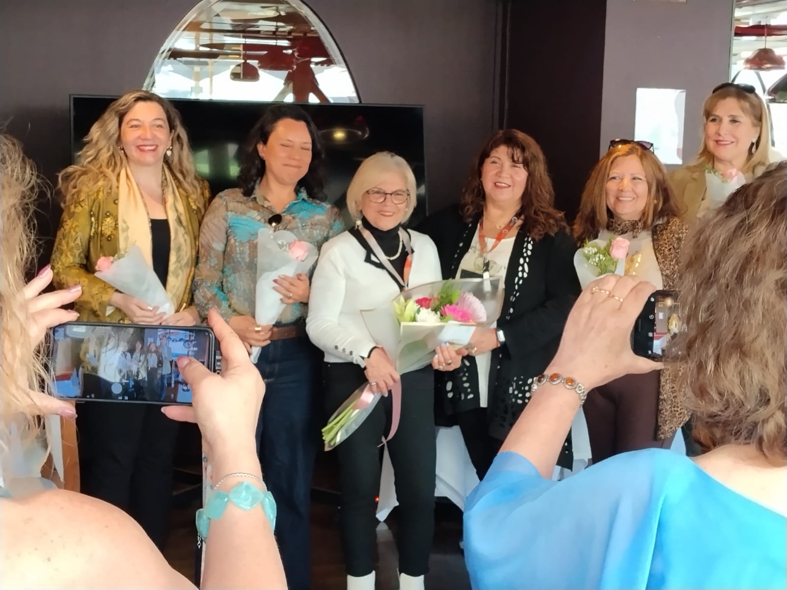 Participantes de AGEPV reciben flores durante la celebración de los 26 años de la asociación